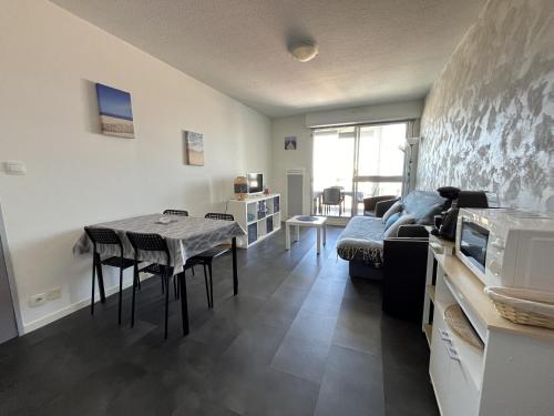 un salon avec une table et un canapé dans l'établissement Le Corsaire, à Saint-Gilles-Croix-de-Vie