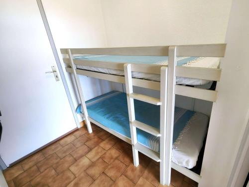 une chambre avec deux lits superposés dans une pièce dans l'établissement Studio cabine climatisé pour 4, piscine, Cap d'Agde - FR-1-607-209, au Cap d'Agde