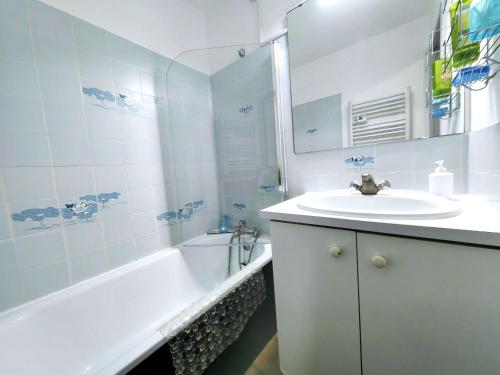 La salle de bains blanche est pourvue d'un lavabo et d'une baignoire. dans l'établissement Studio cabine climatisé pour 4, piscine, Cap d'Agde - FR-1-607-209, au Cap d'Agde