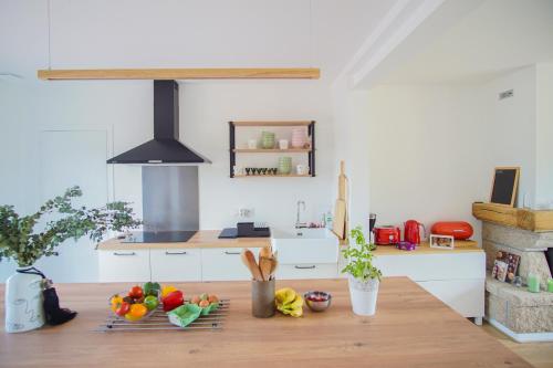 - une cuisine avec une table avec des fruits et des légumes dans l'établissement -GAÏA- MAISON FAMILIALE VUE MER ET JARDIN DOURVEIL, à Trégunc