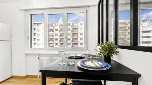 - une table noire avec des verres à vin devant une fenêtre dans l'établissement VELVET - Proche Genève - Au pied du Tram - Wifi Gratuit, à Ambilly