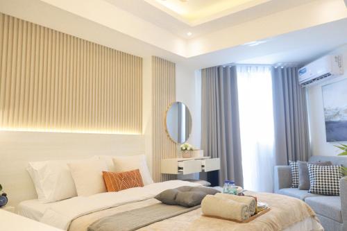 a bedroom with a large bed and a mirror at MRC Homes Azure North Pampanga in San Fernando