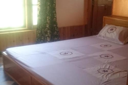 a bed with white sheets in a room with a window at Galaxy Inn by StayApart in Kūfrī