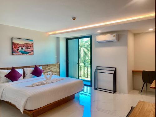 una camera da letto con un grande letto con cuscini viola di Ozone Hotel Khanom a Ban Phang Phrao