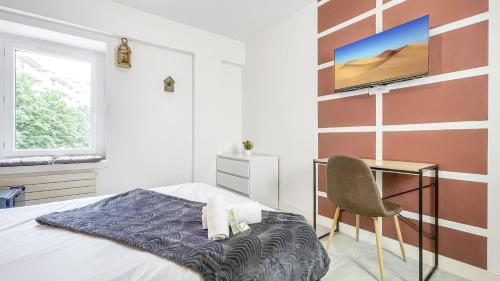 a bedroom with a bed and a desk and a television at LA COLOC CHOCO - Belle Colocation en hypercentre / 5 chambres privées / Salle de bains privative / Proche Gare et Tram / Wifi et Netflix in Annemasse