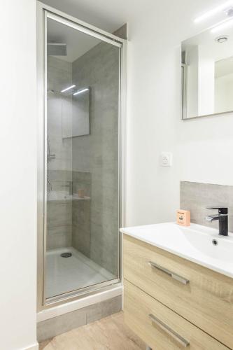 une salle de bain avec une douche en verre et un lavabo dans l'établissement M5 Marquer Beau t2 centre ville, à Annemasse