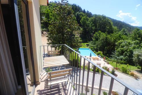 a balcony with a view of a swimming pool at Quinta das Varcandas Gerês Apartamento 3 by Gerês Casas in Geres