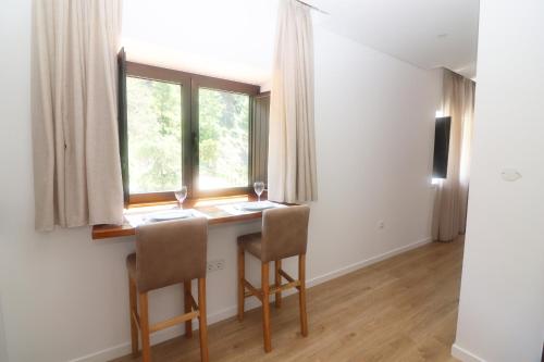 a room with a table with two chairs and a window at Quinta das Varcandas Gerês Apartamento 3 by Gerês Casas in Geres