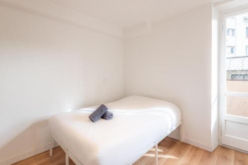 Cette petite chambre d'angle comprend un lit blanc. dans l'établissement M22 studio avec balcon proche de la gare, à Annemasse