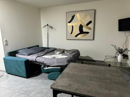 un salon avec deux lits et une table dans l'établissement M12 Marquer joli studio, à Annemasse