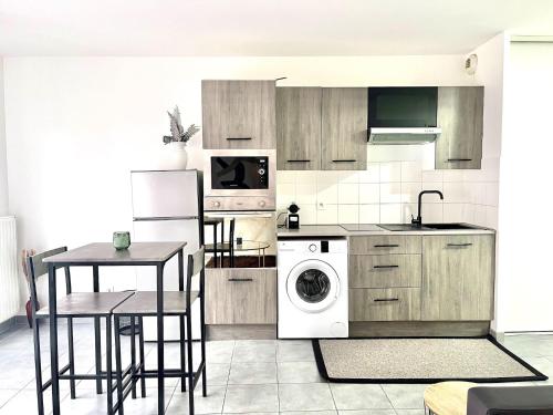 Il comprend une cuisine équipée d'un réfrigérateur, d'une table et d'un lave-linge. dans l'établissement M12 Marquer joli studio, à Annemasse