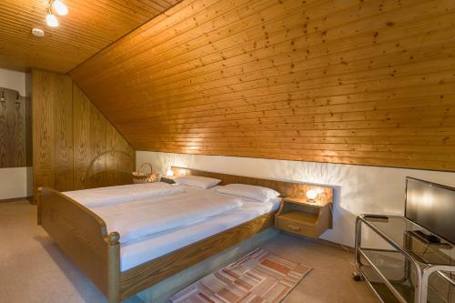 a bed in a room with a wooden ceiling at Drei Tannen - Wohnung 12 - Apartmenthaus, Titisee, nahe Badeparadies in Titisee