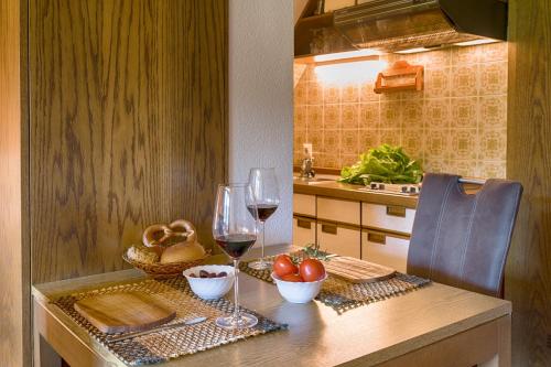 a kitchen with a table with two glasses of wine at Drei Tannen - Wohnung 10 - Apartmenthaus, Titisee, Feldberg in Titisee