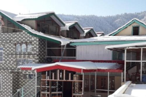 a building under construction with snow on the roofs at Galaxy Inn by StayApart in Kūfrī