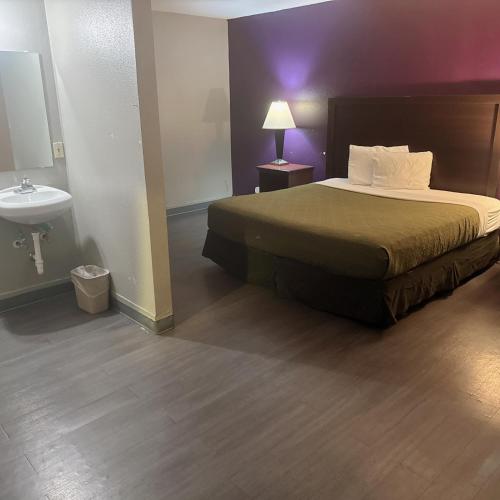 a hotel room with a bed and a sink at Deluxe inn in Bossier City