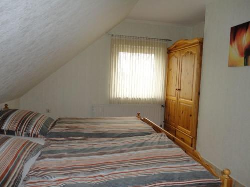 a bedroom with a bed and a wooden cabinet at Kleymann RE26 in Sögel