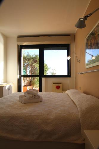 a bedroom with a large bed with two towels on it at Casa LORY in Varazze