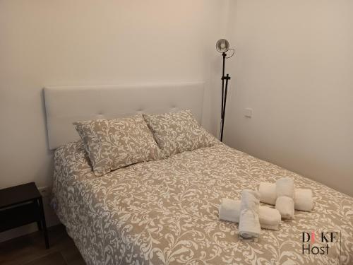 ein Schlafzimmer mit einem Bett mit zwei Handtüchern darauf in der Unterkunft Puerta de Hierro Apartments in Madrid