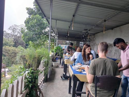 a group of people sitting at tables in a restaurant at Green Peak - Mountain View Hotel & Restaurant in Ella
