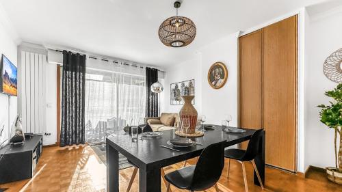 a living room with a black table and chairs at Coloc Dormant - Hyper-centre, proche transports pour Genève. in Annemasse