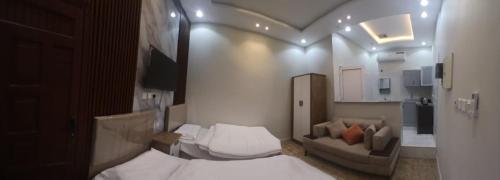 une petite chambre avec deux lits et un canapé dans l'établissement غرفة مفروشة مجمع الشلال, à Djeddah