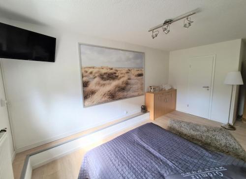a room with a bed and a tv on a wall at Bootshaus Nr 6 in Grömitz