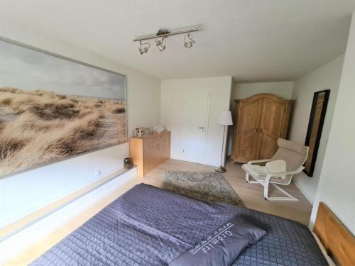 a bedroom with a bed and a chair and a window at Bootshaus Nr 6 in Grömitz