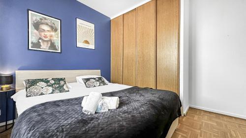 a bedroom with a bed and a blue wall at Coloc Dormant - Hyper-centre, proche transports pour Genève. in Annemasse