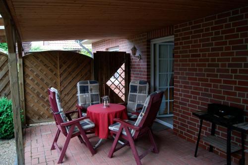 einen roten Tisch und Stühle auf einer Terrasse in der Unterkunft Thesing RE22 in Sögel