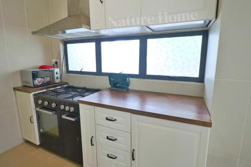 a small kitchen with a stove and a window at Nature Home 2 - Swiss Garden Resort Residences Beachfront Villa in Kuantan
