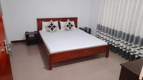 a bed with white sheets and pillows in a room at King Elephant, Homestay Pinnawala in Rambukkana