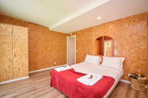 a bedroom with a bed with two towels on it at Penedo Escape Nature in Colares