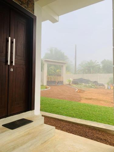 a front door of a house with a view of a yard at Nelumbo Villa 42 - oasis of relaxations in Uragasmanhandiya
