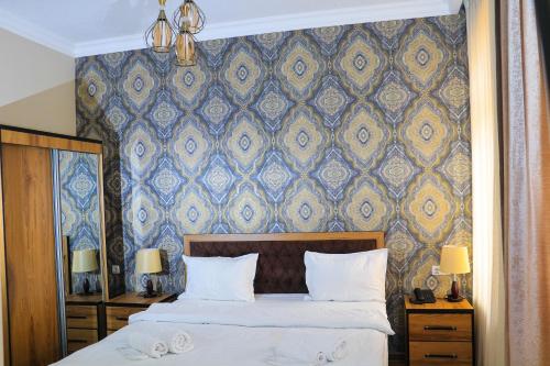 1 dormitorio con 1 cama con una pared azul y dorada en ELANI Hotel, en Samarkand
