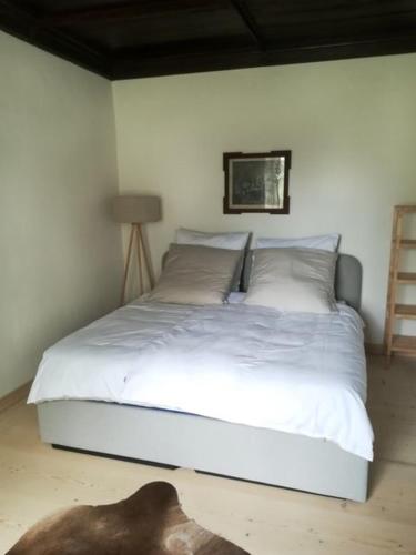 a bed with white sheets and pillows in a bedroom at Ferienwohnung Hofmarkrichterhaus in Polling