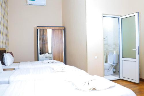 Habitación con 2 camas y baño con aseo. en ELANI Hotel, en Samarkand