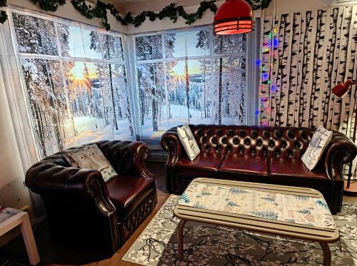 a living room with two leather couches and a window at Relax & Recharge - a Unique Suite with a Touch of Luxury - Hot Tub and Sauna Inspired Decor #NOT A REAL SAUNA# Easy City Access - direct train 15 min to city in Helsinki