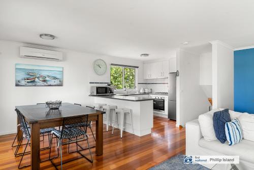 a kitchen and living room with a table and a couch at Seadale in Rhyll