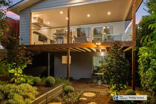 a glass house with a deck with a table and chairs at Seadale in Rhyll