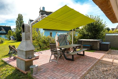 a patio with a table and a yellow umbrella at C 4 Reethaus ELSA mit Außenwhirlpool und Sauna in Gramkow