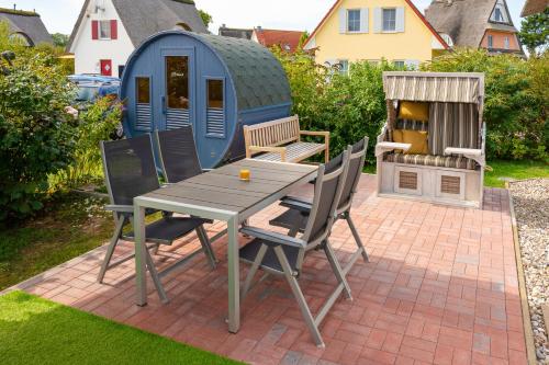 a patio with a table and chairs and a shed at C 5 Premium Reethaus Delphin mit eigenem Whirlpool und Außensauna in Gramkow