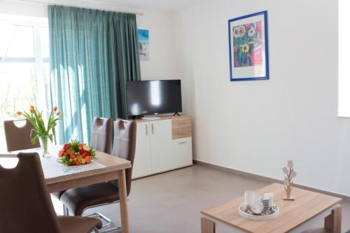 StickHaus 4711 rechtes Haus in Tossens的带桌子和电视的客厅