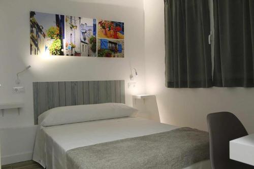 sypialnia z łóżkiem i obrazem na ścianie w obiekcie Hostal royal begoña w Madrycie
