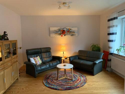 a living room with two leather couches and a table at Ferienwohnung in der Schleife in Rendsburg