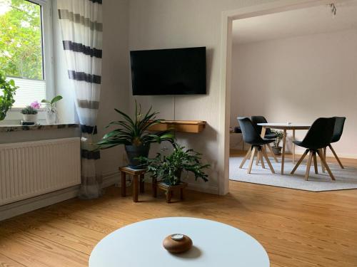 a living room with a tv and a table and chairs at Ferienwohnung in der Schleife in Rendsburg