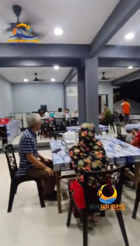 a man sitting at a table in a restaurant at Perhentian Najmi Hotel in Perhentian Island