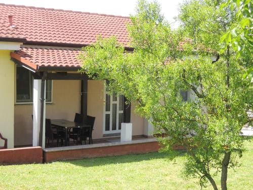 dom z patio ze stołem i krzesłami w obiekcie Residence Lorena Bungalow Lavanda 1 w Poreču