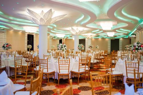 a banquet hall with white tables and chairs at Grand Avalon in Pothuhera