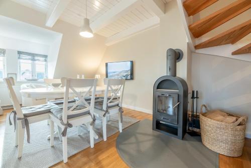 a living room with a wood stove and a table at Landhaus am Meer - Whg 7 Osterley in Utersum
