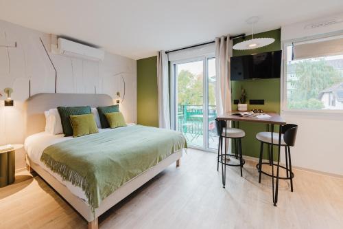 a bedroom with a bed and a desk and a window at Appart Hotel Neostelia in Annecy